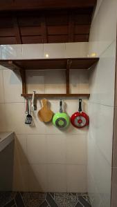 a row of kitchen utensils hanging on a wall at Sayong Wooden House in Ubud +27 photos