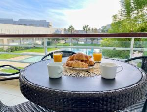 a table with a breakfast of croissants and orange juice at Casa Maria Vera in Lagos