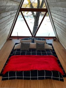 a large bed in a room with a large window at Escaper at Nereju Star Place in Carşocheşti