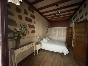a bedroom with a bed and a vase of flowers at Casa La Candelaria - Moya in Moya