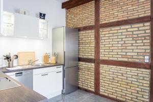 a kitchen with a brick wall and a refrigerator at Mien Tied MITTENMANG in Heiligenhafen