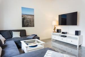 a living room with a couch and a tv at Mien Tied MITTENMANG in Heiligenhafen