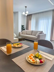 two plates of fruit on a table in a living room at Elysian Escape Apartment in Sarandë