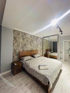 a bedroom with a bed and a large mirror at Уютные квартиры в Бишкеке in Bishkek +7 photos