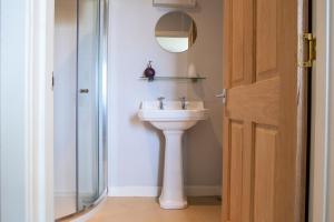 un bagno con lavandino, specchio e doccia di Poolewe Hotel a Poolewe