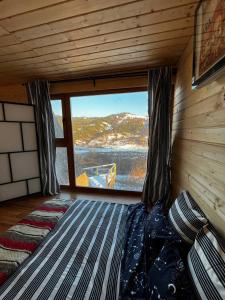 a bed in a room with a large window at Escaper at Nereju Star Place in Carşocheşti +30 photos