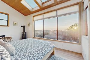 une chambre avec un lit et une grande fenêtre dans l'établissement Del Mar Meadow, à Sea Ranch 22 autres photos
