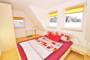 Un dormitorio con una cama y dos ventanas. en Ferienhaus Timm, en Kellenhusen