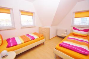 Dos camas en una habitación con dos ventanas. en Ferienhaus Timm, en Kellenhusen 5 fotos más