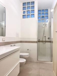 une salle de bain blanche avec douche et toilettes dans l'établissement Best Stay-Theatre Suite Apartment, à Bari