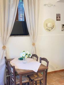 Una mesa de comedor con un jarrón de flores encima. en Taorminacentre IN TOWN, en Taormina