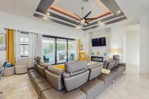 ein Wohnzimmer mit einem großen Sofa und einem Fernseher in der Unterkunft Oasis Haven in Cape Coral