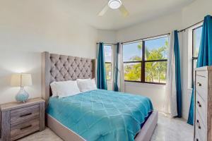 ein Schlafzimmer mit einem Bett mit blauen Laken und einem Fenster in der Unterkunft Oasis Haven in Cape Coral + 17 Fotos