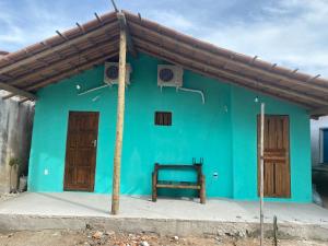 a green house with a blue wall and a basketball hoop at Raizes da Terra - Ponta do Corumbau in Corumbau