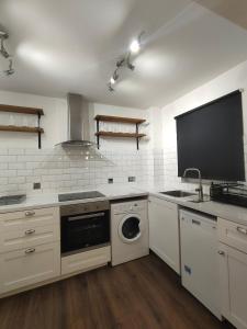 a kitchen with a washer and a sink and a dishwasher at Free Parking 4 Beds Flat 15 min train to Victoria London Bridge St Paul Cathedral in London