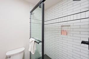 baño con aseo y puerta de ducha de cristal en Seventh Mt 1418 condo, en Bend