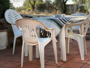 un tavolo con 4 sedie e un tavolo con una tovaglia di Casa Pereiro a Monte de Jangeis de Cima