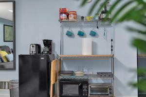 a kitchen with a microwave and a shelf with utensils at 1 BR Suite w Fenced Backyard - Parking! in Tucker