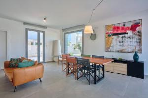 a living room with a couch and a table and chairs at Villa Canepa in Marsala