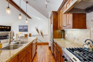 cocina con armarios de madera, fregadero y fogones en Luxury Mountain Townhome, en Ketchum