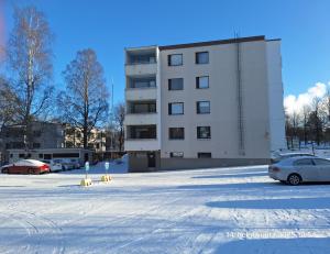 Un estacionamiento con autos estacionados frente a un edificio. en Tyylikäs kaksio keskustasta parkkipaikalla,wifi, en Lappeenranta