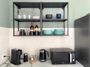 a kitchen counter with a microwave and bottles of wine at Villa Canepa in Marsala