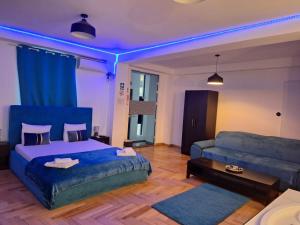 a bedroom with a bed and a couch at RIS Studio premium lux jacuzzi in Bucharest