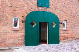 a green door on the side of a brick building at Ferienwohnung Helmsstraße II in Ebstorf