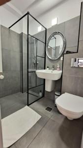 a bathroom with a toilet and a sink and a mirror at RIS Studio premium lux jacuzzi in Bucharest