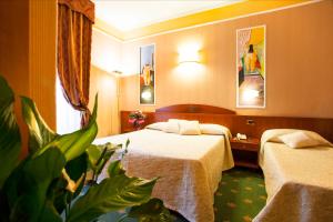 蒙特卡蒂尼泰尔梅Boutique Hotel Puccini的一间酒店客房,配有两张床和植物
