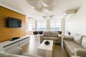 a living room with a couch and a tv at Saint Moritz Hotel em Brasília 63939 in Brasilia