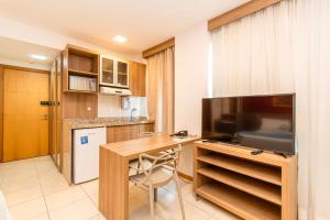 a kitchen with a desk and a television in a room at Saint Moritz Hotel em Brasília 63939 in Brasilia