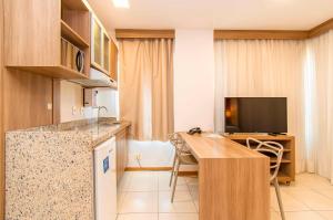 a room with a kitchen and a table and a television at Saint Moritz Hotel em Brasília 63939 in Brasilia +27 photos