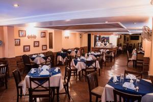 a dining room with tables and chairs with blue tablecloths at Hotel Villa Española in Guatemala