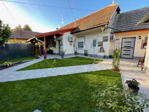 a backyard of a house with a lawn at Royal Gold Apartman in Kiskunhalas