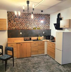 a kitchen with wooden cabinets and a white refrigerator at Apartament blu in Piece +9 photos