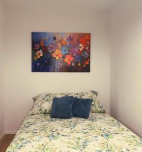 una camera da letto con un letto e un dipinto sul muro di Apartament blu a Piece