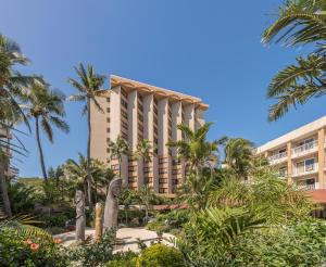 a hotel with palm trees in front of it at Nouvata in Noumea