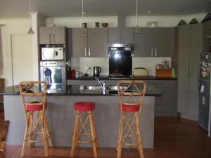 a kitchen with two bar stools and a counter at Jade Bed & Breakfast in Blenheim