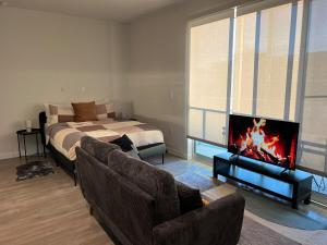 a living room with a bed and a couch and a tv at Santa Monica Bright Studio with stunning view in Los Angeles
