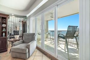 a living room with glass doors and a chair at Beachfront Bliss! 1800 sq ft Spacious 3BR Sleeps 12 - Oceans 9D in Gulf Shores +34 photos