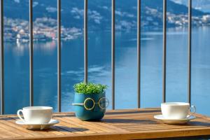 多布罗塔Dobrota Sea View apartment by MN Property的一张桌子,上面放着两个咖啡杯和盆子