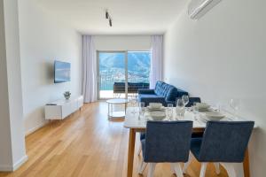 多布罗塔Dobrota Sea View apartment by MN Property的一间带桌椅的餐厅和客厅