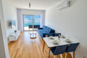 多布罗塔Dobrota Sea View apartment by MN Property的客厅里有一张蓝色的沙发和一张桌子