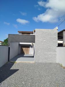 a white house with a garage at Sobrado São Chico, Ubatuba SFS in São Francisco do Sul