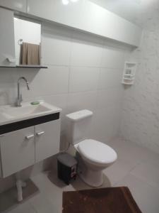a white bathroom with a toilet and a sink at Sobrado São Chico, Ubatuba SFS in São Francisco do Sul