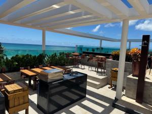 a patio with tables and chairs and a view of the ocean at Hoa Beach in Tamandaré