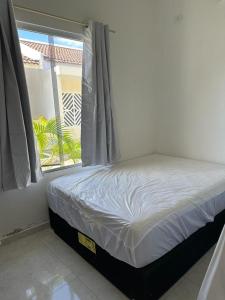 a bed sitting in a room with a window at Casa de praia PB in Pitimbu