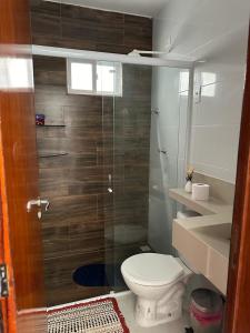 a bathroom with a toilet and a glass shower at Casa de praia PB in Pitimbu