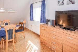 a living room with a flat screen tv and a dining table at Ferienwohnung Schneider in Bannesdorf